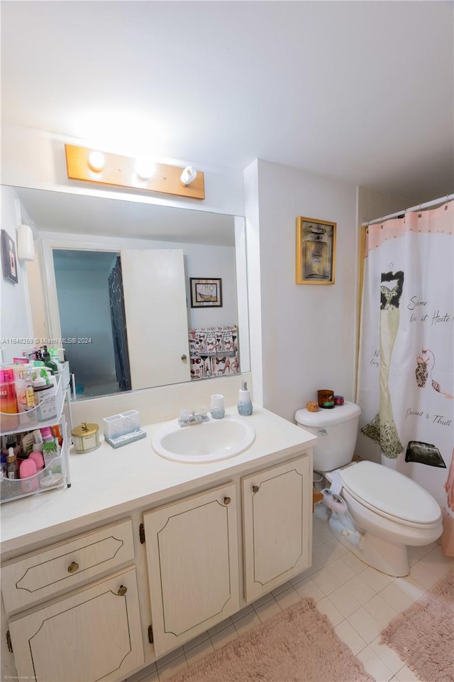 bathroom featuring curtained shower, tile patterned flooring, toilet, and vanity