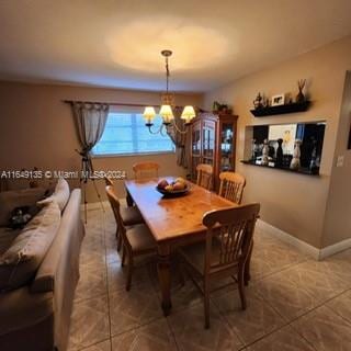 dining area with tile patterned flooring and an inviting chandelier