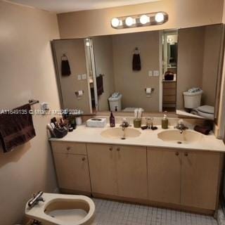 bathroom with vanity, toilet, a bidet, and tile patterned floors