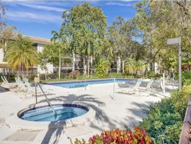 view of swimming pool with a community hot tub and a patio area