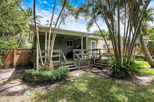 rear view of property featuring a wooden deck and ceiling fan