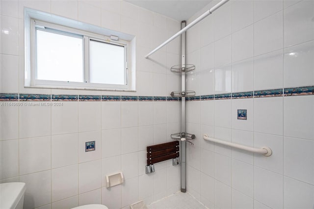 bathroom featuring tile walls and toilet