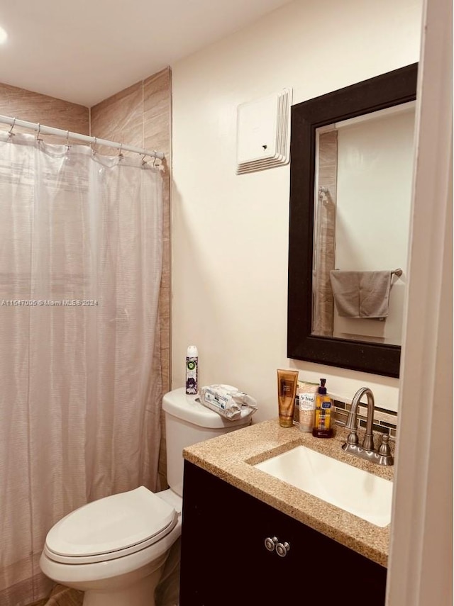 bathroom with a shower with shower curtain, vanity, and toilet