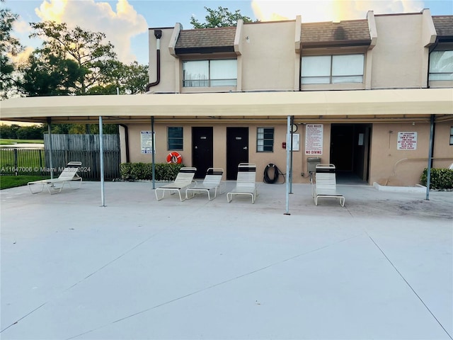 back house at dusk with a patio and a carport