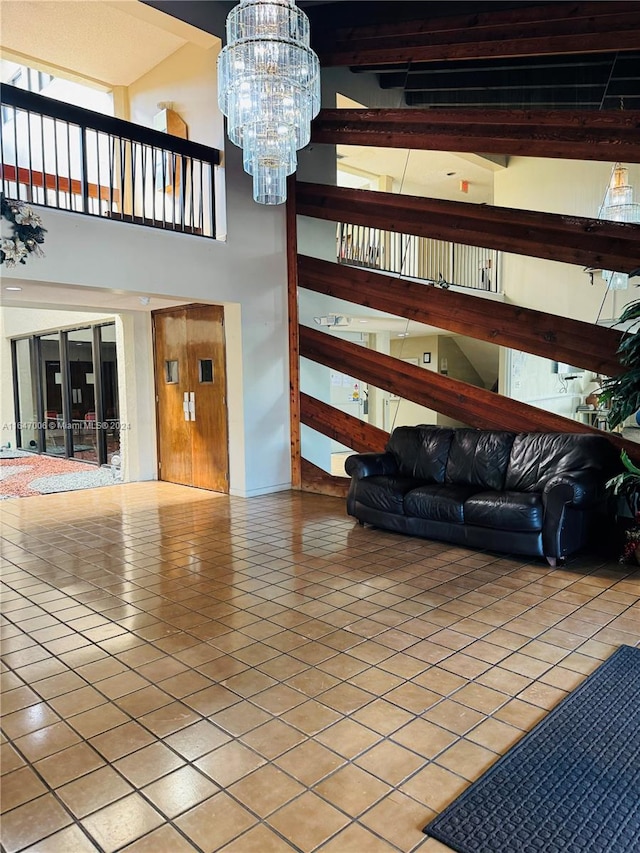 unfurnished living room with a high ceiling, beam ceiling, an inviting chandelier, and tile patterned floors