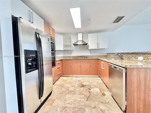 kitchen with light tile patterned floors, stainless steel appliances, sink, light stone counters, and wall chimney range hood