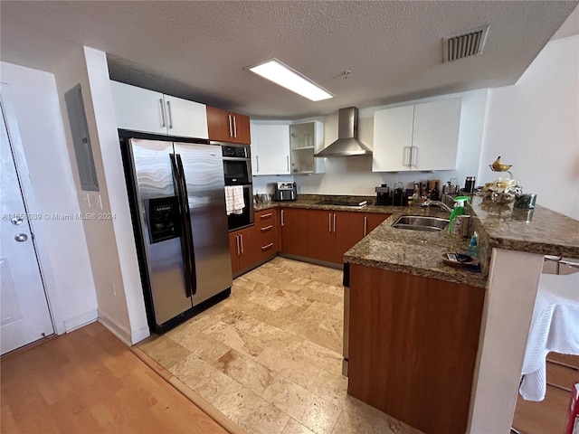 kitchen featuring dark stone countertops, stainless steel appliances, white cabinetry, wall chimney range hood, and light tile patterned flooring