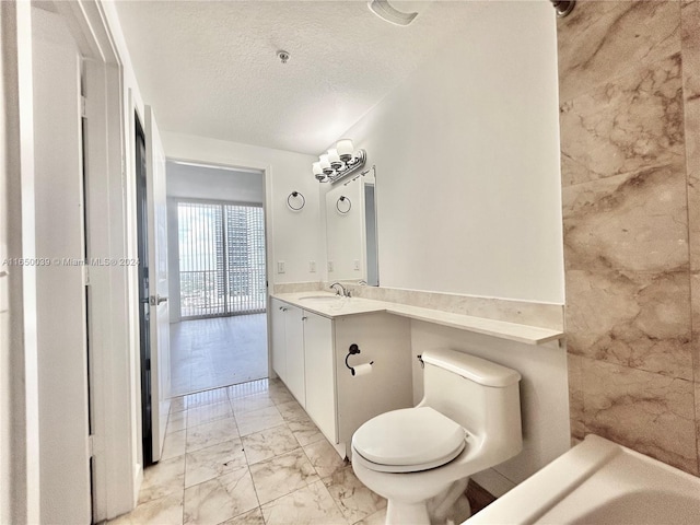 bathroom with toilet, tile patterned floors, vanity, a textured ceiling, and a bath