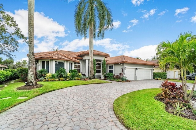 mediterranean / spanish-style house featuring a garage and a front lawn