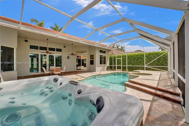 view of pool featuring a lanai, a hot tub, a patio, ceiling fan, and french doors