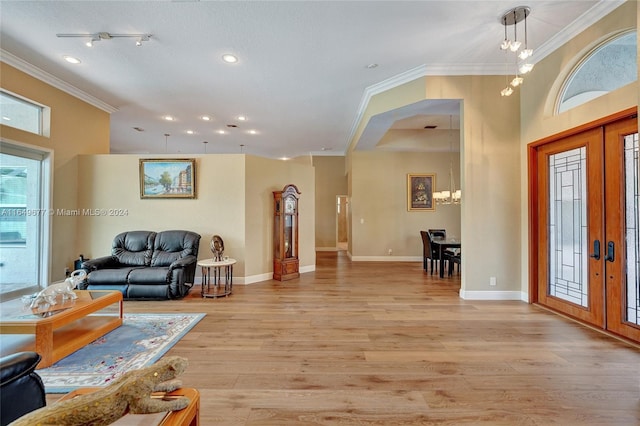 living room featuring light wood-type flooring, crown molding, and french doors