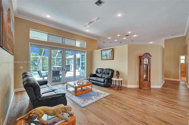 living room with hardwood / wood-style flooring, ornamental molding, a textured ceiling, and french doors