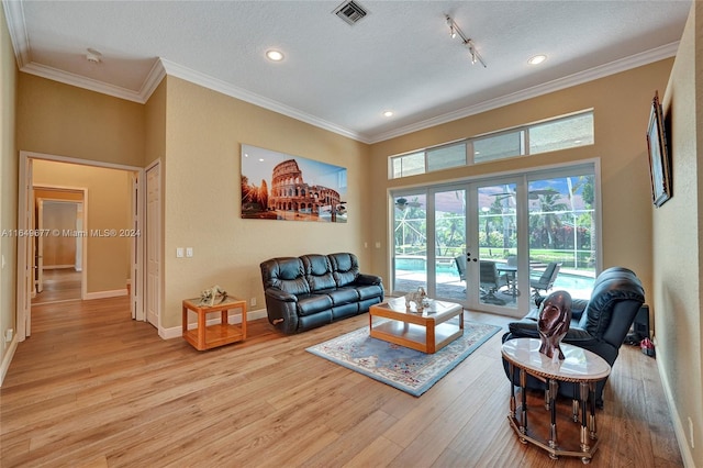 living room featuring ornamental molding, french doors, a textured ceiling, and hardwood / wood-style floors