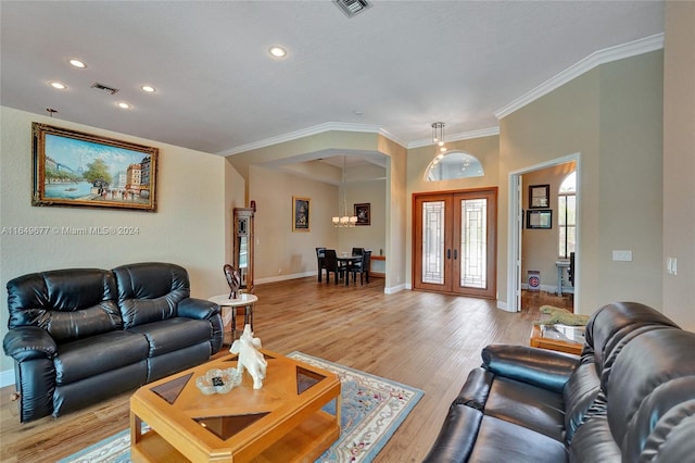 living room featuring crown molding, light wood-type flooring, and french doors