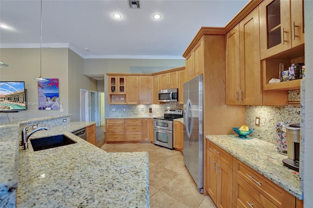 kitchen with hanging light fixtures, appliances with stainless steel finishes, light stone counters, sink, and decorative backsplash