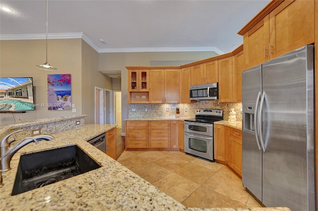 kitchen with hanging light fixtures, appliances with stainless steel finishes, light stone counters, sink, and decorative backsplash