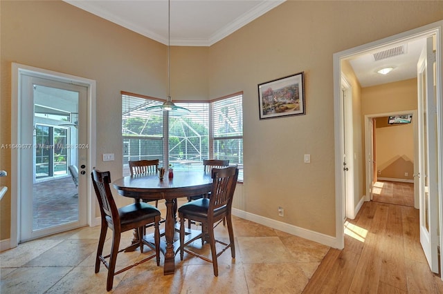 dining room with crown molding and light hardwood / wood-style flooring