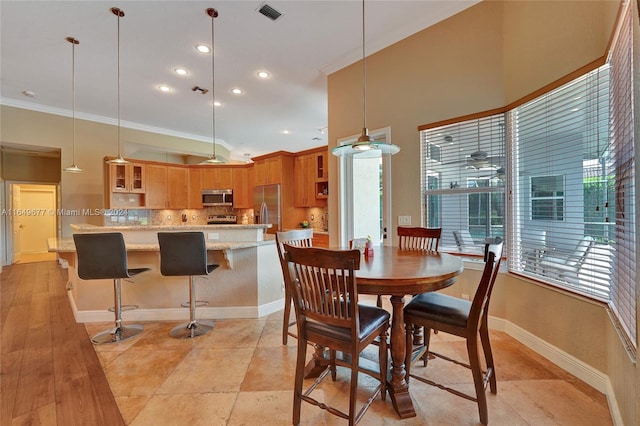 dining space featuring light hardwood / wood-style flooring and ornamental molding