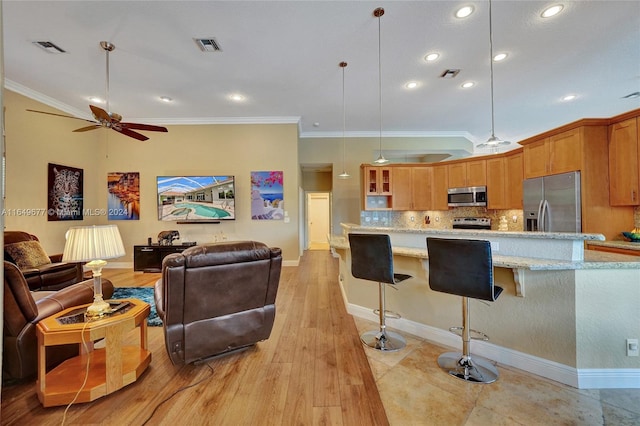 kitchen with pendant lighting, light hardwood / wood-style floors, stainless steel appliances, ceiling fan, and light stone counters