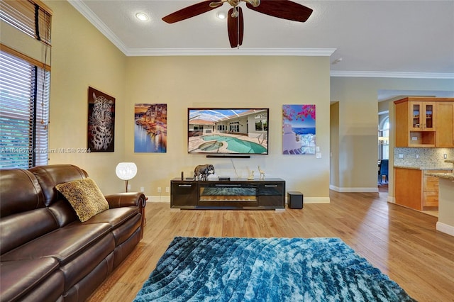 living room featuring crown molding, light hardwood / wood-style flooring, and ceiling fan