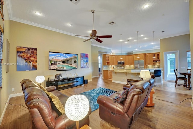 living room with light hardwood / wood-style flooring, ceiling fan, and ornamental molding