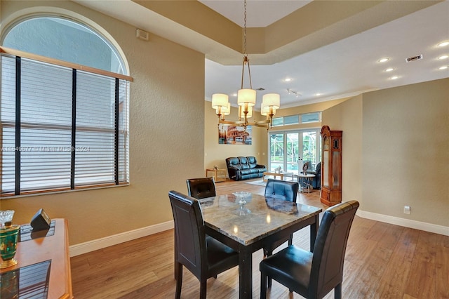 dining room featuring wood-type flooring and an inviting chandelier