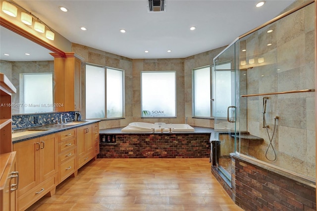 bathroom with vanity, tile walls, wood-type flooring, and shower with separate bathtub