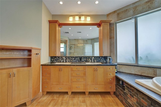 bathroom featuring vanity, independent shower and bath, wood-type flooring, and tasteful backsplash