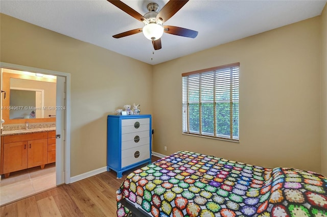 bedroom featuring ceiling fan, sink, ensuite bathroom, and light hardwood / wood-style floors