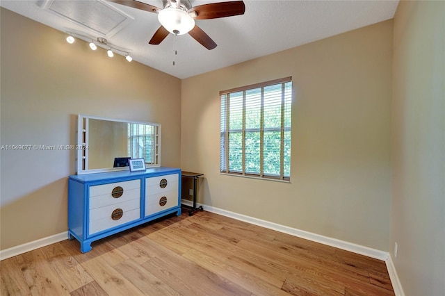 bedroom featuring track lighting, ceiling fan, and light hardwood / wood-style floors