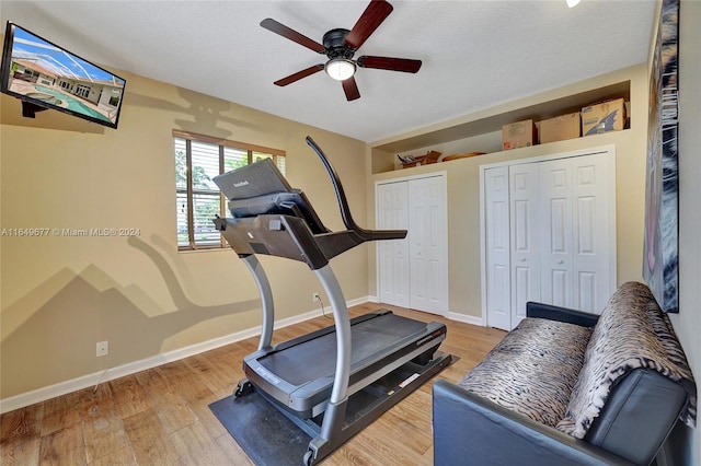 workout area featuring hardwood / wood-style floors, ceiling fan, and a textured ceiling