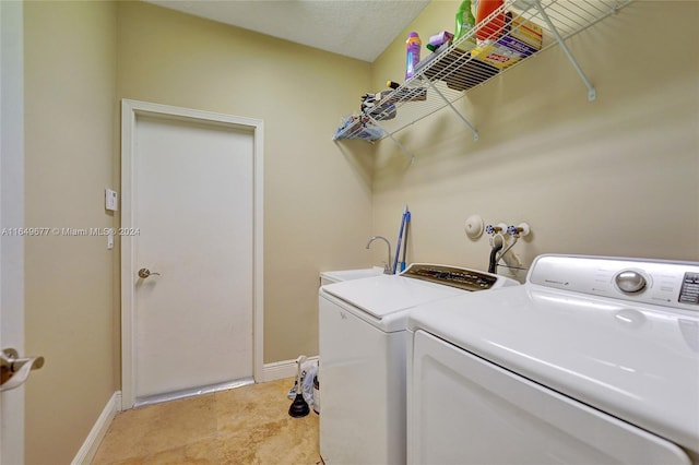 washroom with independent washer and dryer and sink