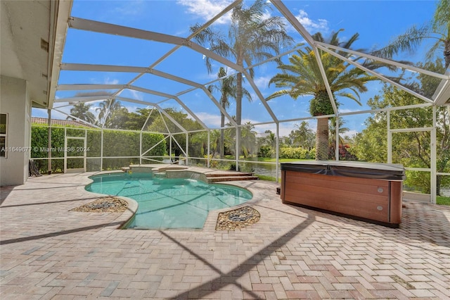 view of pool featuring a lanai, a patio area, and a hot tub