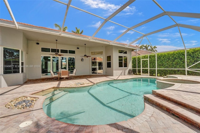 view of swimming pool with a lanai, a patio area, an in ground hot tub, ceiling fan, and french doors