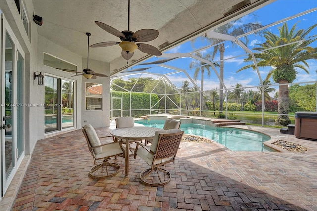 view of swimming pool featuring ceiling fan, a lanai, a patio, and an outdoor hot tub