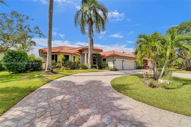 mediterranean / spanish-style house featuring a garage and a front yard