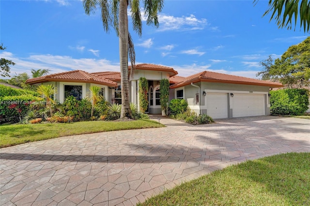 mediterranean / spanish house featuring a garage and a front yard