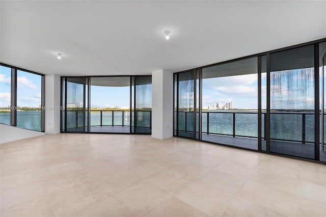 empty room featuring floor to ceiling windows and a water view