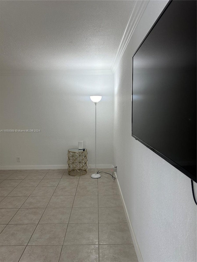 tiled spare room with a textured ceiling and crown molding