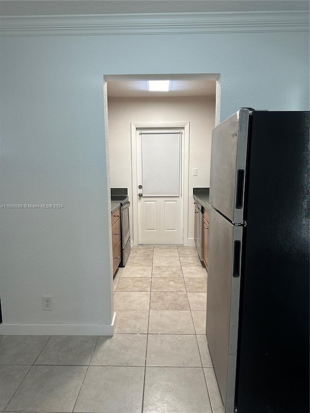 kitchen with crown molding, light tile patterned floors, and stainless steel appliances