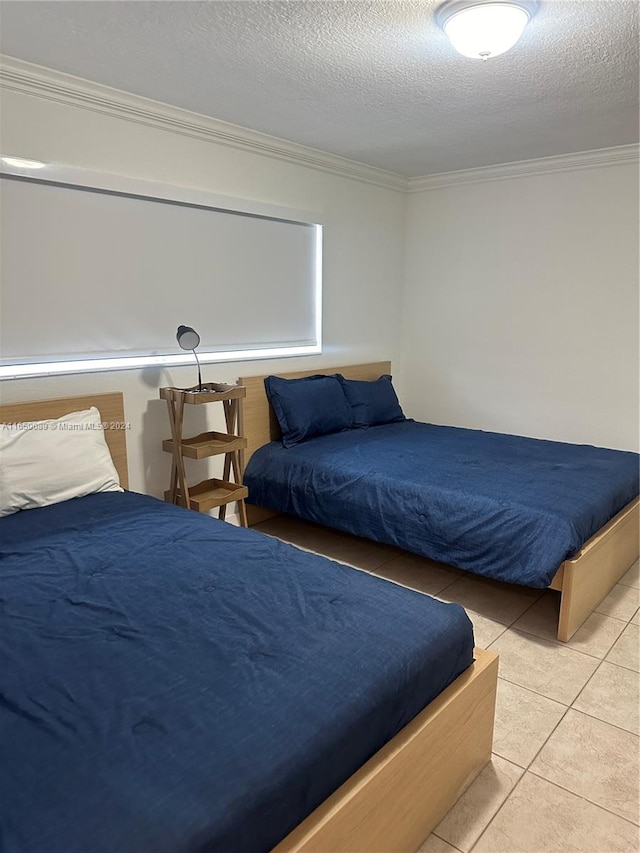 bedroom with a textured ceiling, crown molding, and light tile patterned floors