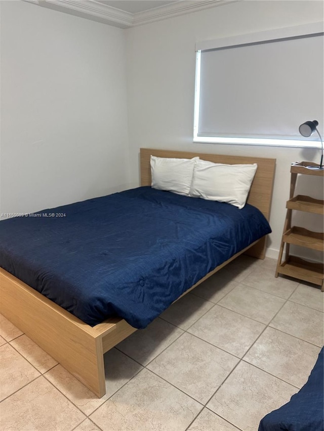 unfurnished bedroom featuring ornamental molding and light tile patterned floors