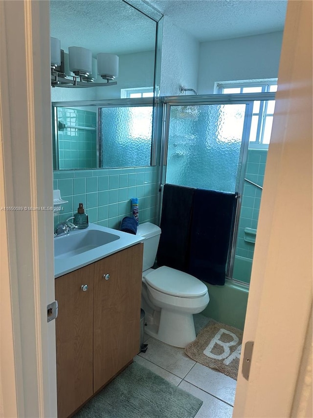 full bathroom featuring toilet, tile patterned floors, vanity, backsplash, and tile walls