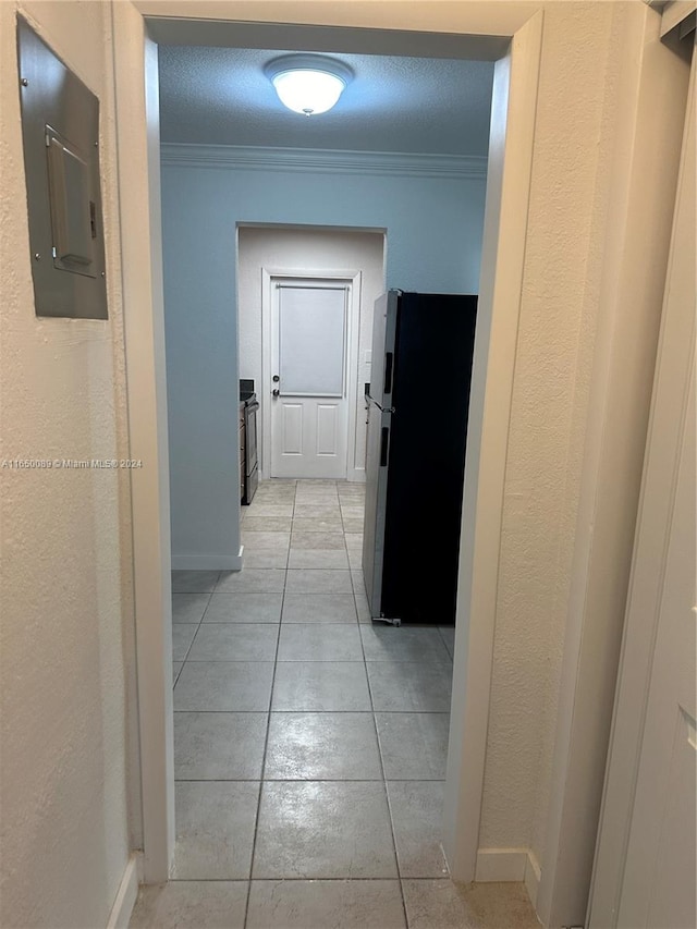 corridor featuring ornamental molding, a textured ceiling, light tile patterned floors, and electric panel