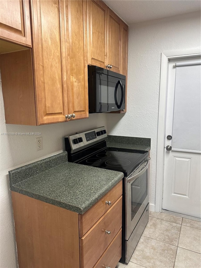 kitchen with light tile patterned floors and stainless steel electric stove