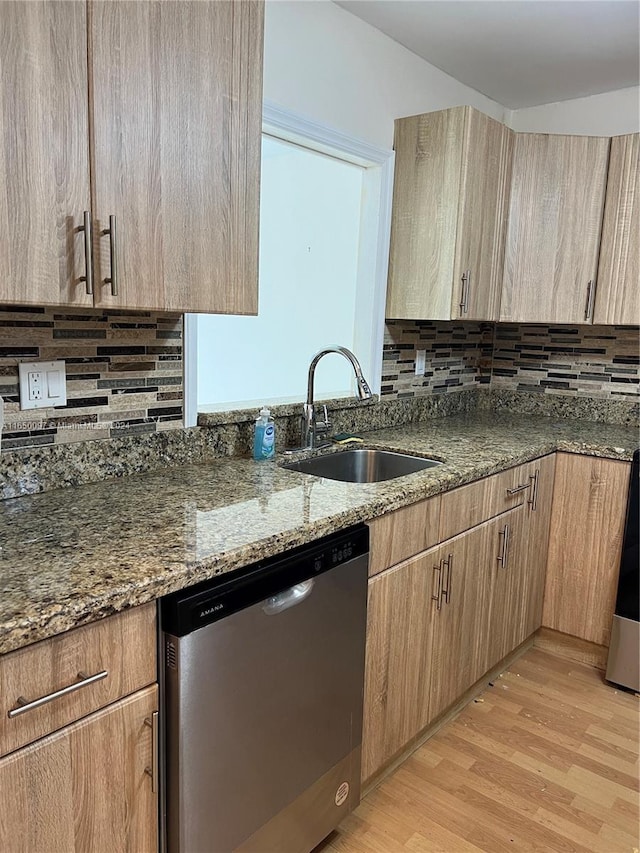 kitchen with decorative backsplash, light wood-type flooring, sink, dark stone countertops, and dishwasher