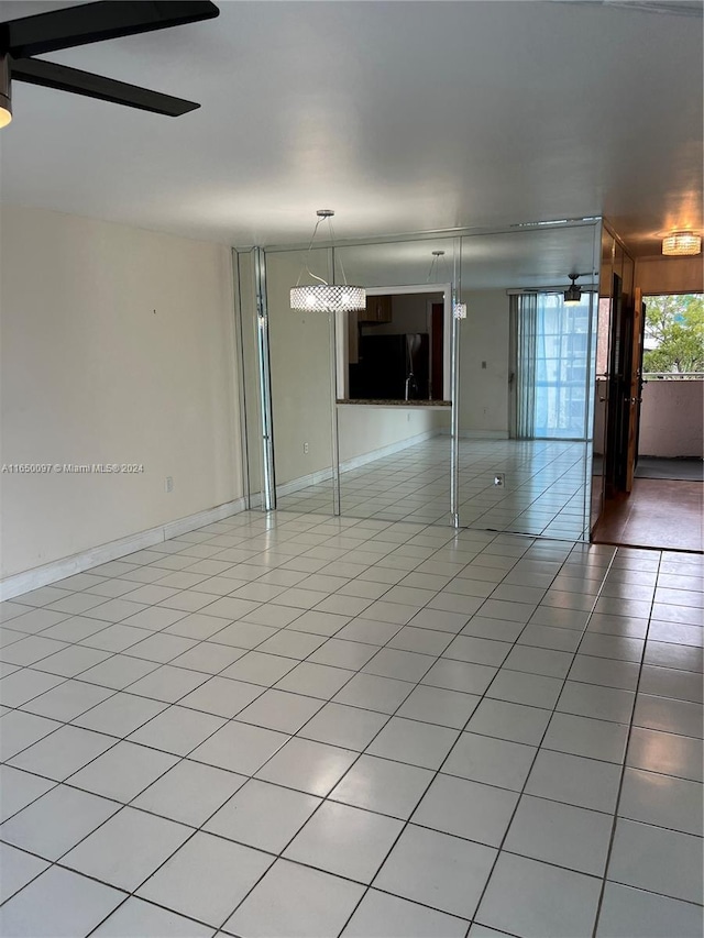 tiled spare room featuring ceiling fan