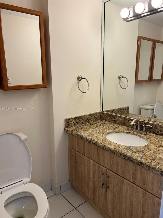 bathroom with tile patterned floors, vanity, and toilet