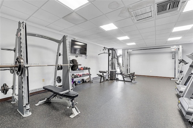 exercise room with a drop ceiling and crown molding