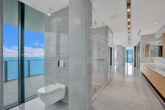 19575 Collins Ave Unit 33, Sunny Isles Beach, FL 33160 - full bathroom featuring toilet, tile walls, double vanity, tile patterned flooring, and a water view